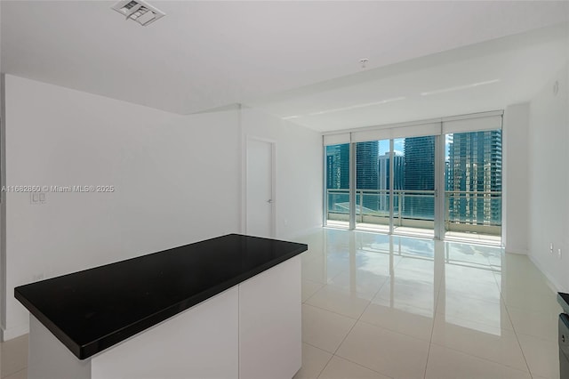 tiled empty room with floor to ceiling windows