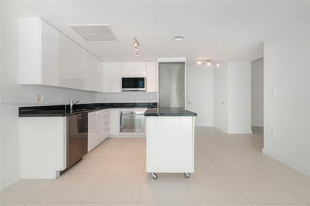 kitchen with white cabinets, light tile patterned flooring, sink, and stainless steel appliances