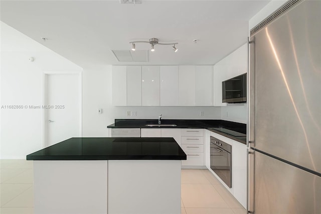 kitchen with sink, light tile patterned floors, a kitchen island, white cabinets, and black appliances