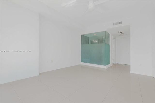 tiled empty room featuring ceiling fan