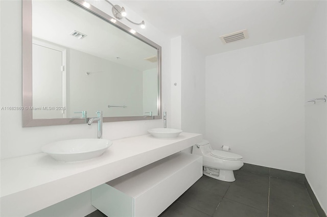 bathroom featuring tile patterned flooring, vanity, and toilet