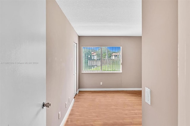 spare room with light hardwood / wood-style flooring and a textured ceiling