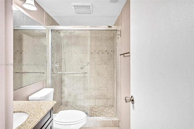 bathroom with tile patterned floors, vanity, toilet, and walk in shower