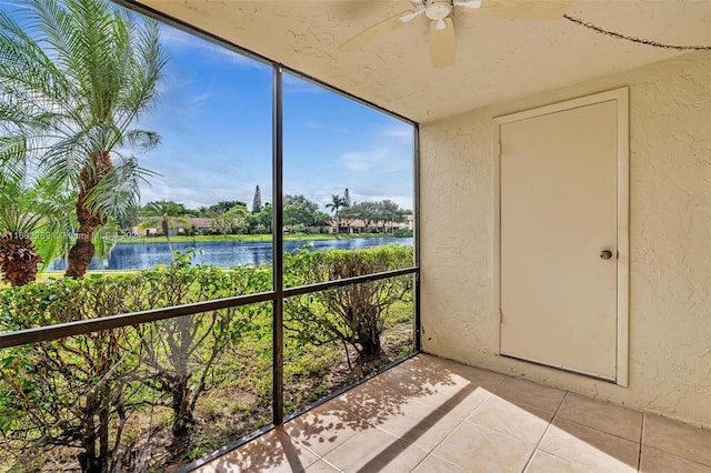 unfurnished sunroom with a water view and ceiling fan