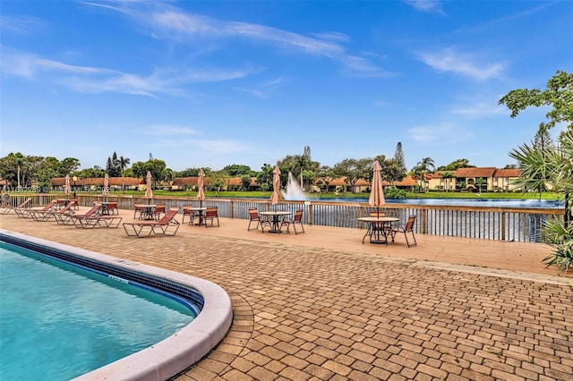 view of swimming pool with a patio area and a water view