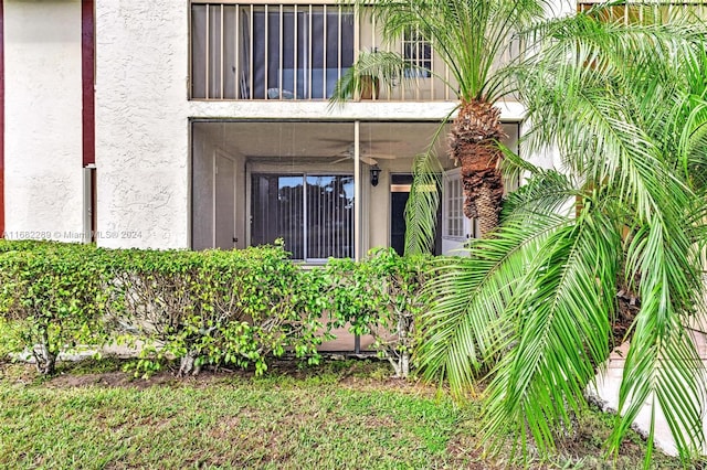 view of exterior entry with a balcony and ceiling fan