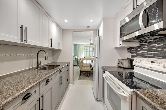 kitchen featuring white cabinets, sink, and white appliances