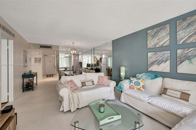 living room featuring a textured ceiling, a notable chandelier, and carpet floors