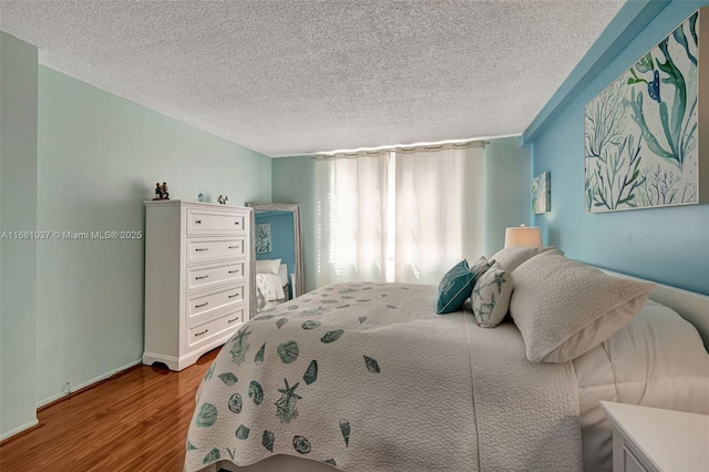 bedroom with light wood-type flooring and a textured ceiling