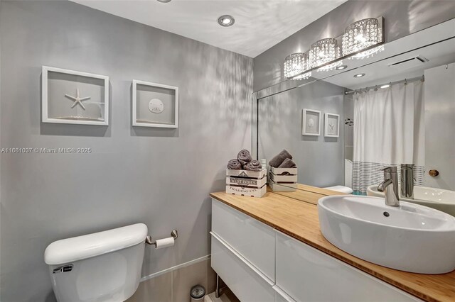 bathroom with toilet, a shower with curtain, and vanity