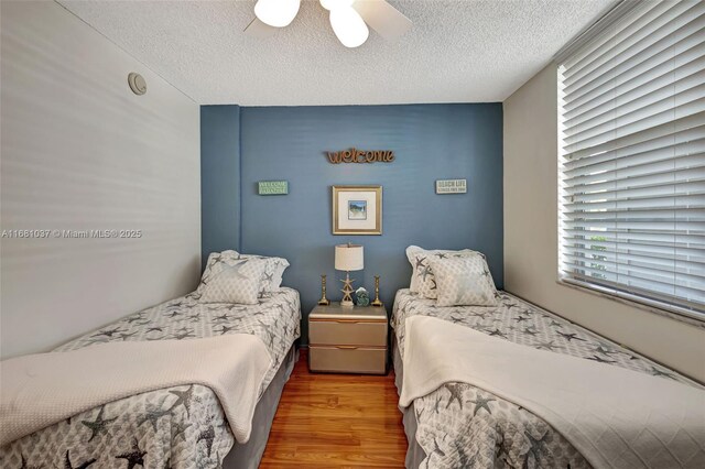 bedroom featuring a textured ceiling, hardwood / wood-style floors, and ceiling fan