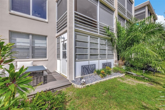 view of property exterior featuring a lawn and a deck