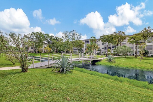 view of property's community with a lawn and a water view