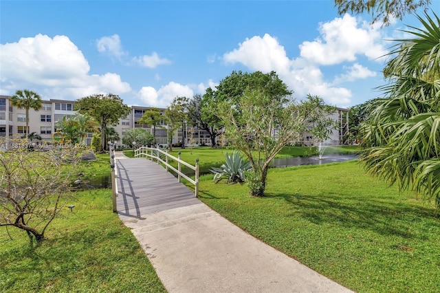 view of property's community featuring a yard and a water view