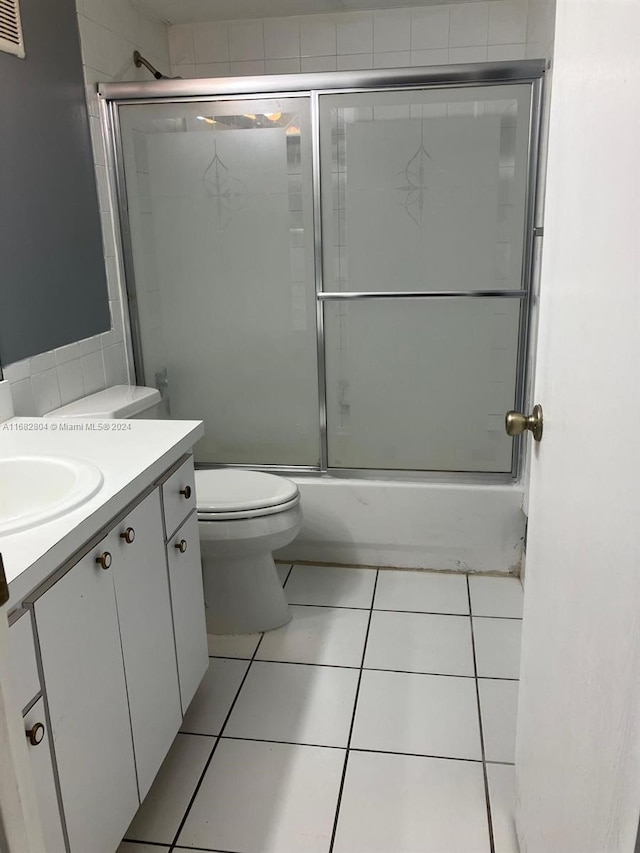 full bathroom with vanity, toilet, shower / bath combination with glass door, and tile patterned flooring