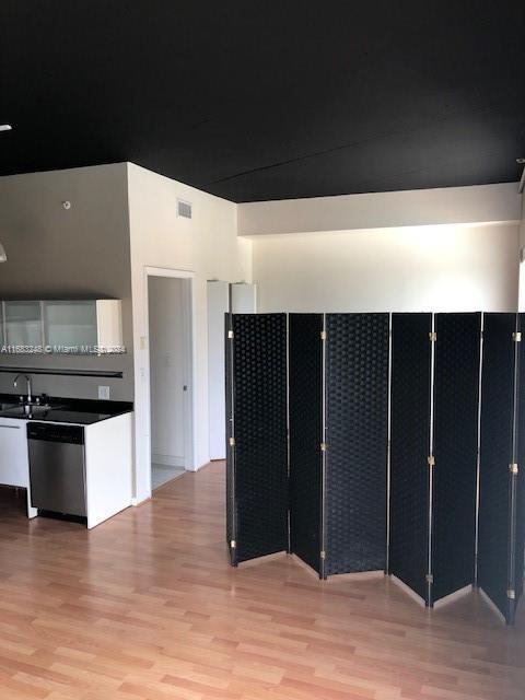 kitchen featuring light hardwood / wood-style flooring, stainless steel dishwasher, and sink