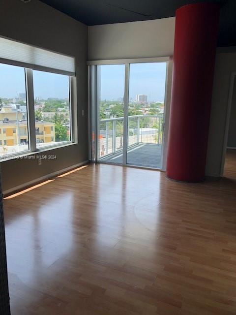 unfurnished room with hardwood / wood-style flooring