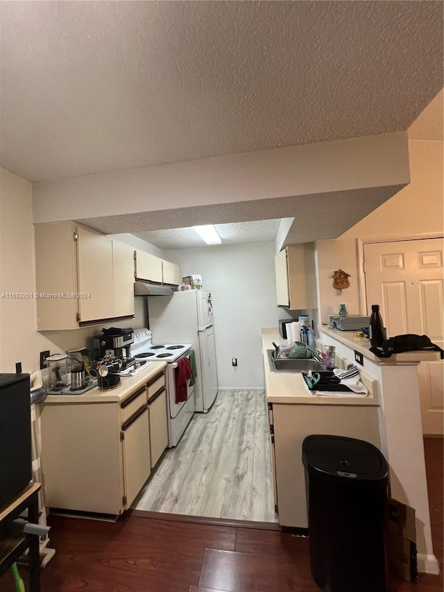 kitchen featuring white appliances, sink, white cabinets, a textured ceiling, and light hardwood / wood-style floors