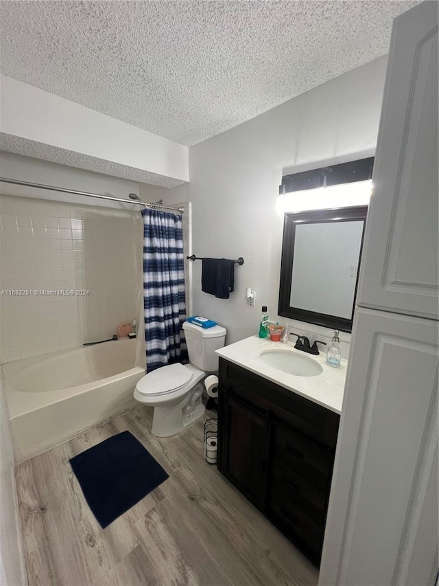 full bathroom featuring hardwood / wood-style floors, a textured ceiling, toilet, shower / bath combo, and vanity