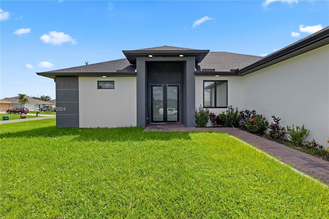 view of exterior entry featuring a yard and french doors