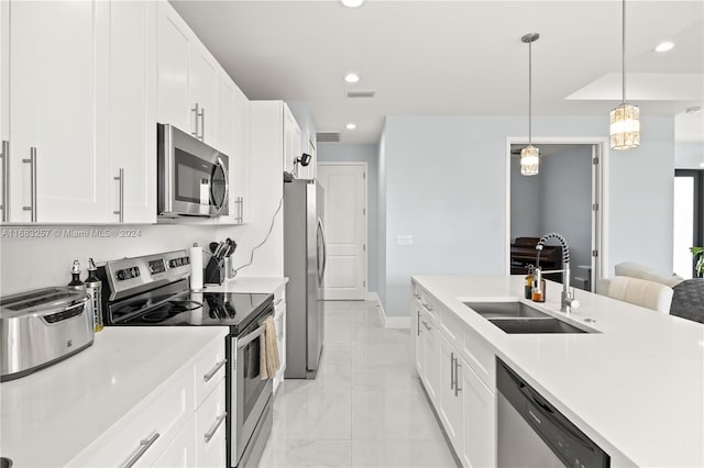 kitchen with hanging light fixtures, white cabinetry, sink, and appliances with stainless steel finishes