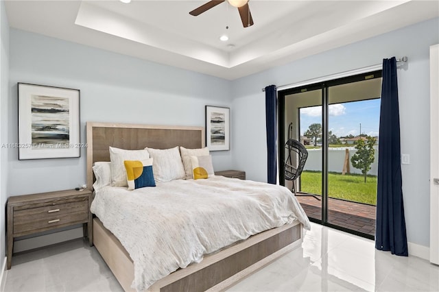 bedroom with a raised ceiling, access to exterior, and ceiling fan