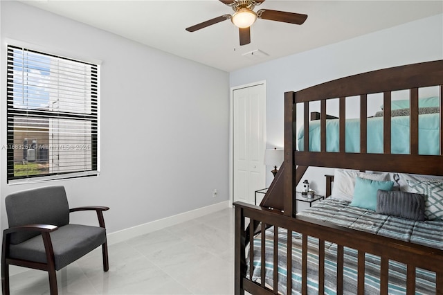 tiled bedroom with ceiling fan and a closet