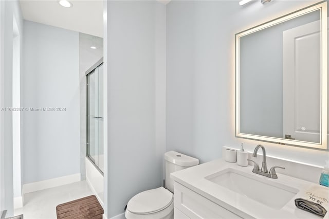 full bathroom with vanity, toilet, and enclosed tub / shower combo