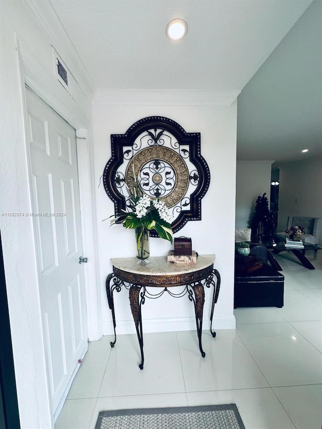 corridor featuring light tile patterned floors and ornamental molding