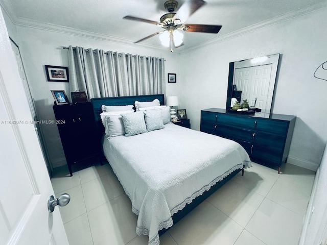 tiled bedroom with a closet, ceiling fan, and crown molding