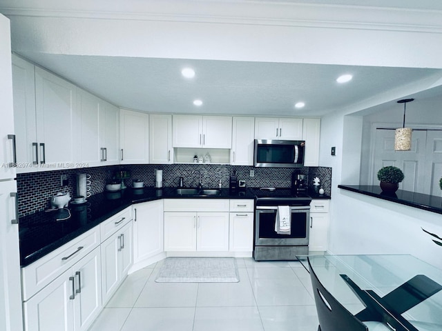 kitchen with white cabinets, decorative backsplash, appliances with stainless steel finishes, and sink