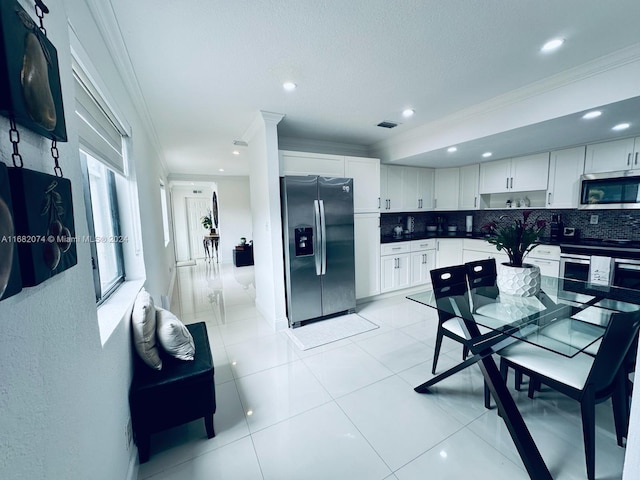 kitchen featuring appliances with stainless steel finishes, decorative backsplash, crown molding, and white cabinets