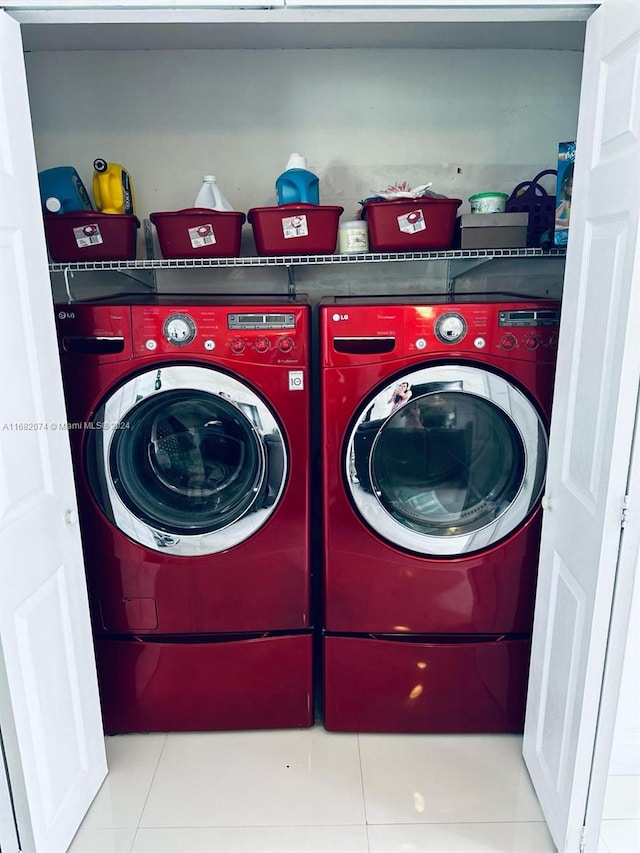 clothes washing area featuring light tile patterned floors and washer and clothes dryer