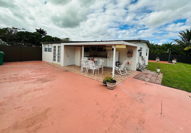 back of property with a lawn and a patio area