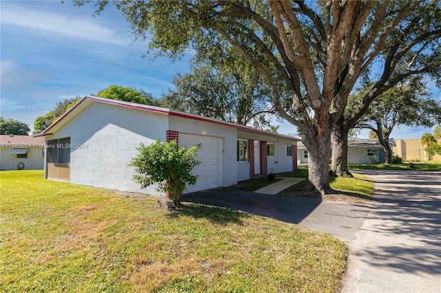 ranch-style home featuring a garage and a front lawn