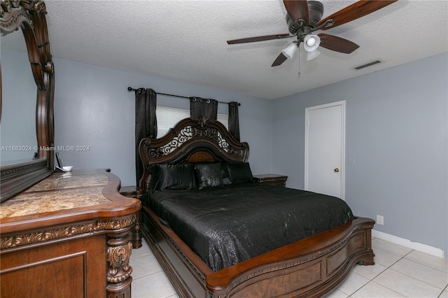 tiled bedroom featuring a textured ceiling and ceiling fan