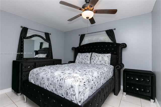 bedroom with a textured ceiling, tile patterned floors, and ceiling fan