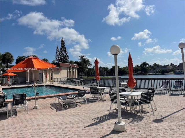 view of swimming pool featuring a patio and a water view