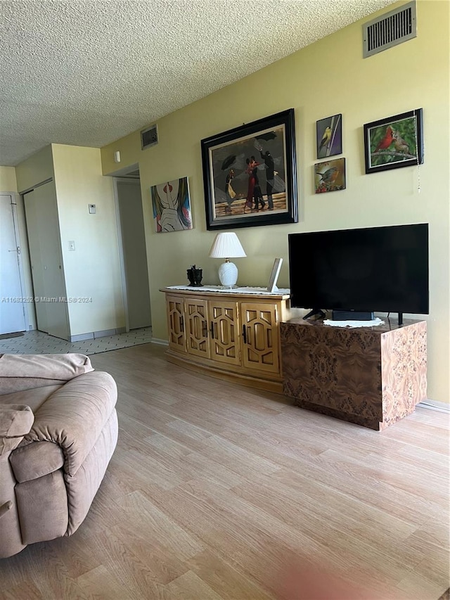 living room with light hardwood / wood-style flooring and a textured ceiling