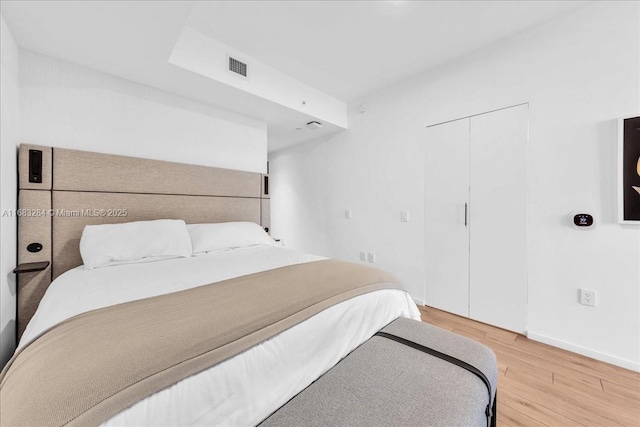 bedroom with wood-type flooring and a closet