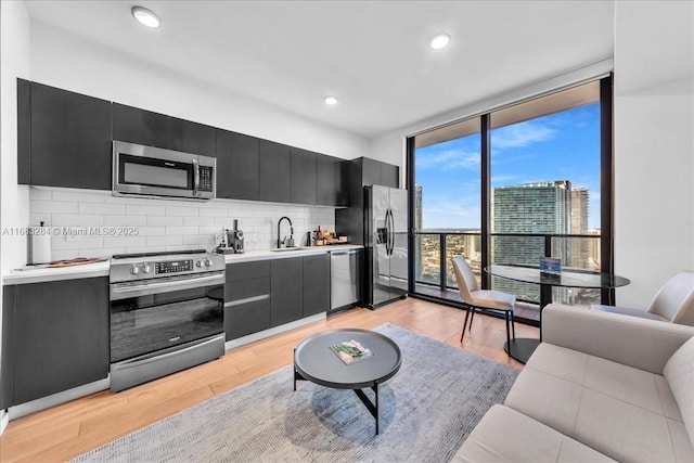 398 NE 5th St Unit 3707, Miami, FL 33132 - kitchen with appliances with stainless steel finishes, expansive windows, dark cabinetry, a sink, and tasteful backsplash
