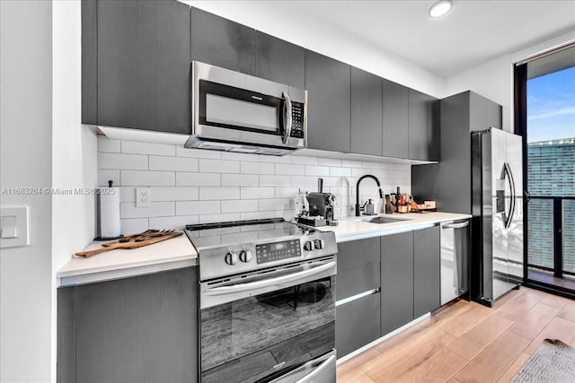398 NE 5th St Unit 3707, Miami, FL 33132 - kitchen featuring stainless steel appliances, a sink, backsplash, light wood finished floors, and floor to ceiling windows