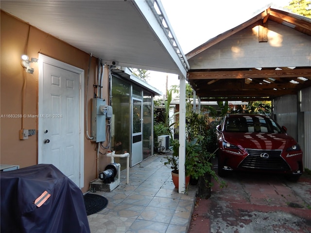 exterior space featuring grilling area, a sunroom, and a carport