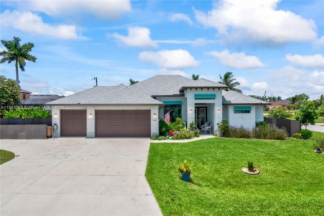 prairie-style home featuring a garage and a front lawn