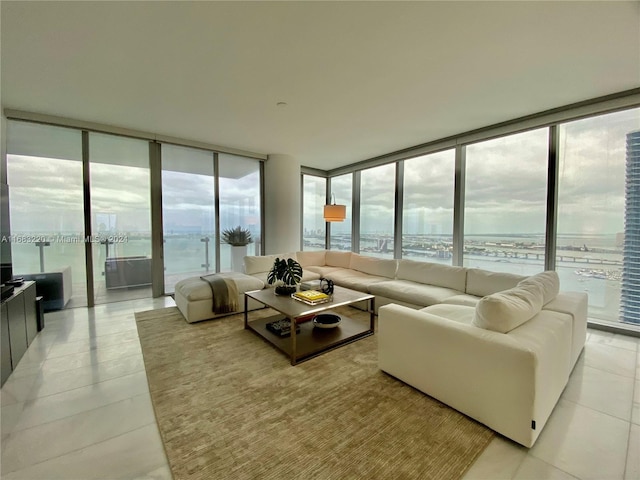 living room featuring a water view, light tile patterned floors, and floor to ceiling windows