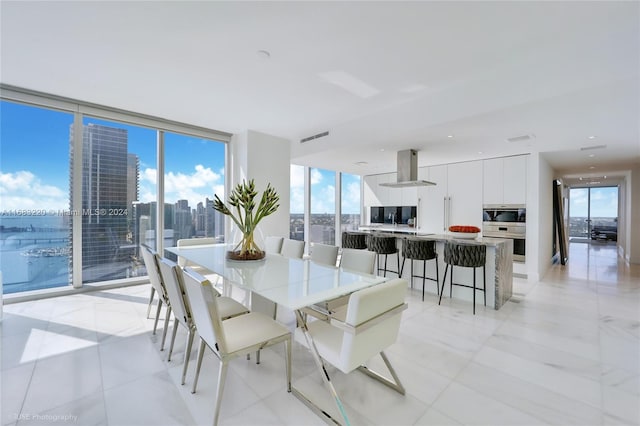 tiled dining room featuring a wall of windows and plenty of natural light