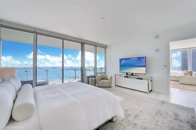 tiled bedroom featuring a wall of windows and access to exterior