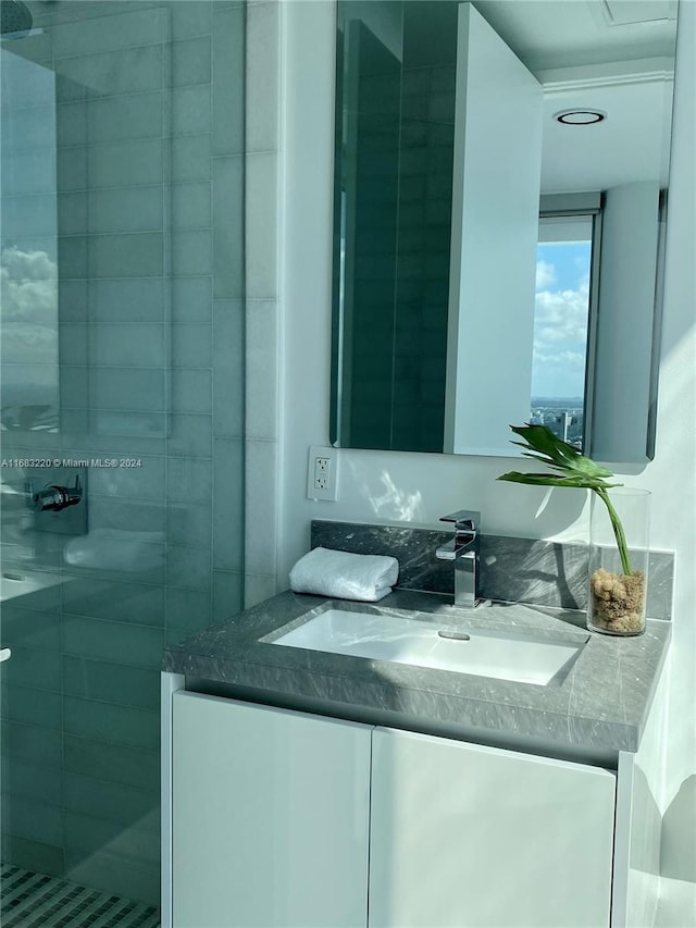 bathroom with vanity and a tile shower