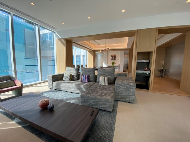 living room with expansive windows, a tray ceiling, and carpet flooring