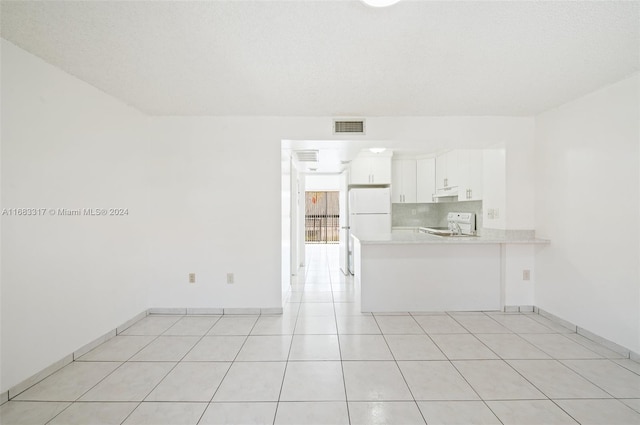 interior space with a textured ceiling and light tile patterned floors